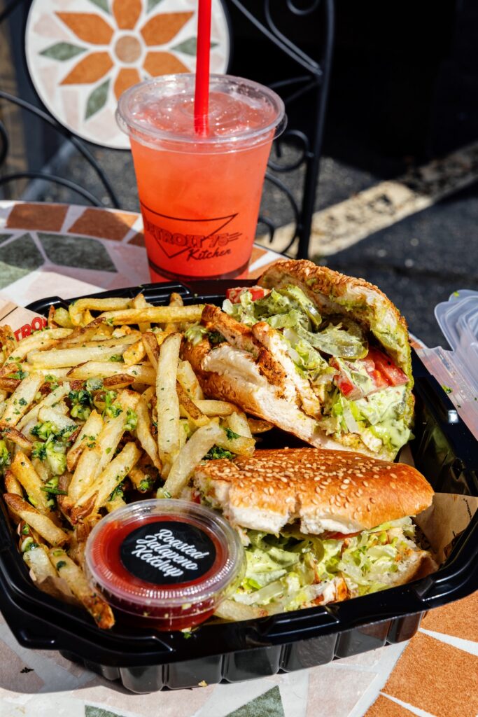 Detroit 75 Kitchen's Atwater Chicken Sandwich with fries, roasted jalapeño ketchup, and pink lemonade
