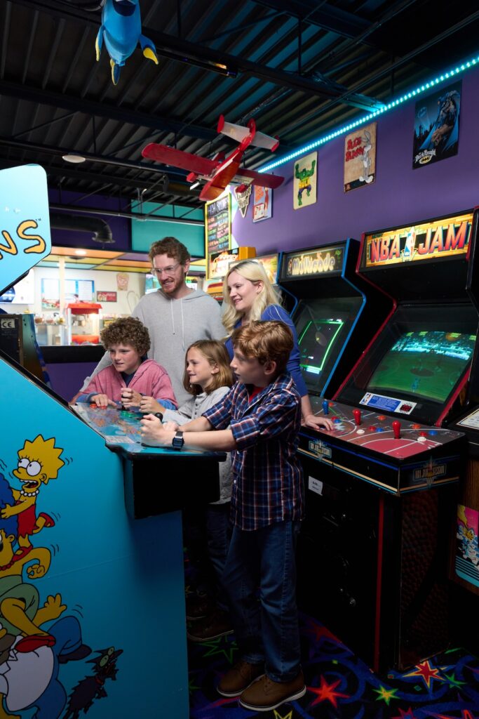 Group with kids playing arcade games at High Score Ice Cream & Arcade