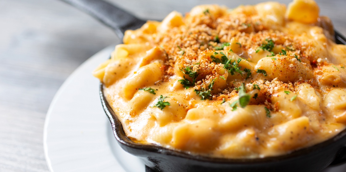 A view of a rustic crumble macaroni and cheese dish in a skillet. - mac and cheese