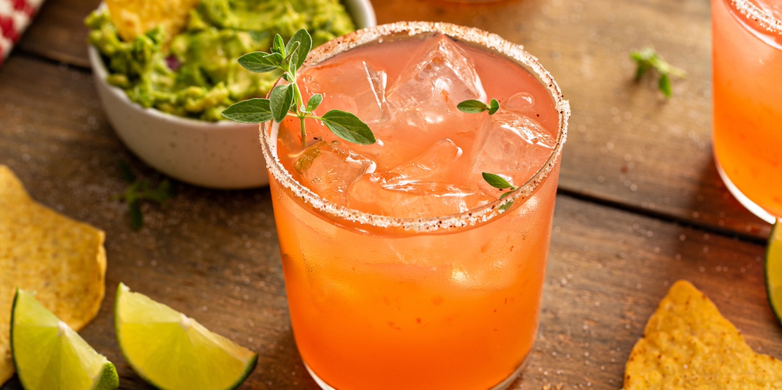 Spicy grapefruit margarita with chili salt rim, served with chips, lime slices and guacamole
