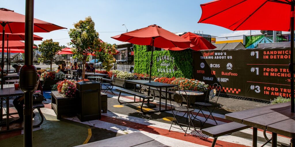 detroit 75 kitchen patio with red umbrellas and greenery