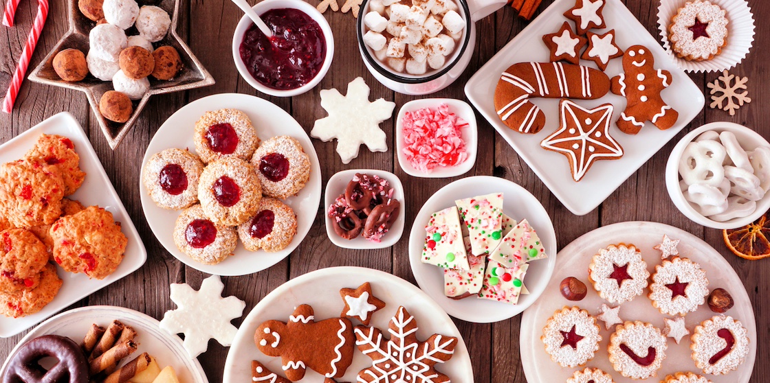 Christmas table scene of assorted sweets and cookies. Top view over a rustic wood background. Holiday baking concept.