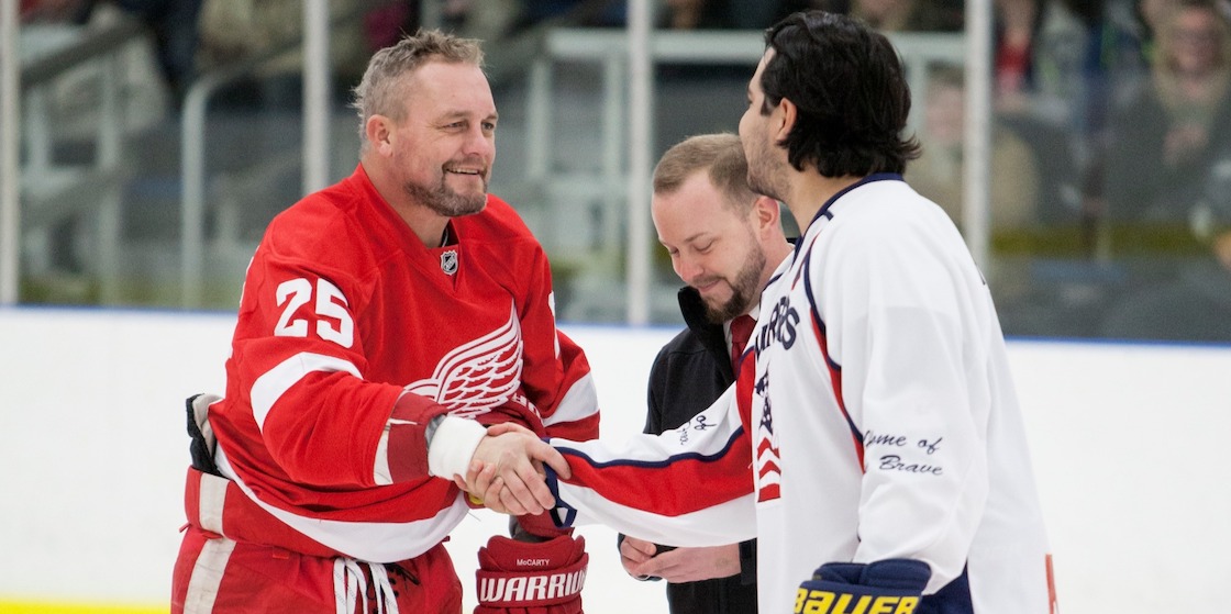 Former Red wings Darren McCarty shakes hand of Michigan Warriors hockey player