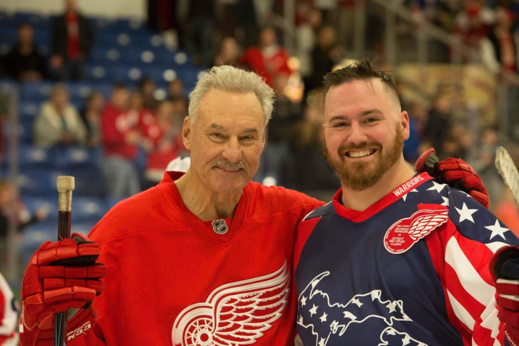 Former Red Wing and color commentator Micky Redmond smiles for on-ice photo with Michigan Warriors hockey player