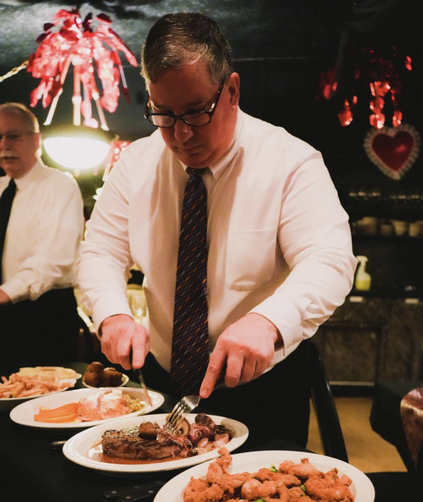 server cuts steak tableside at Mr. Paul's Chophouse