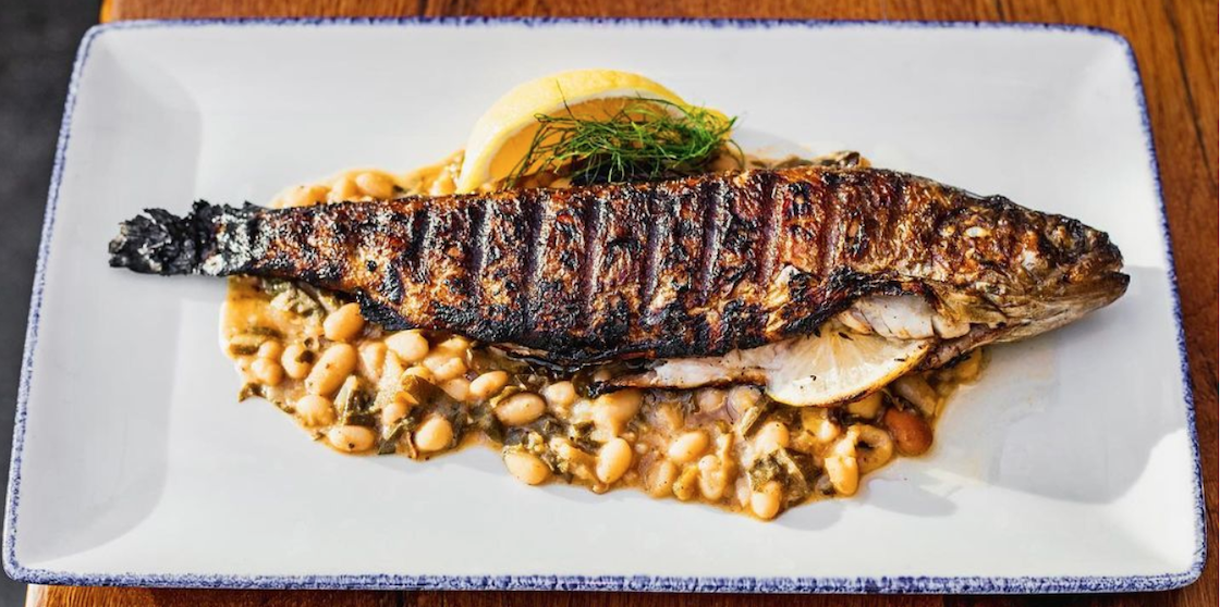 Whole trout served atop navy beans and lemon braised winter greens from Sylvan Table