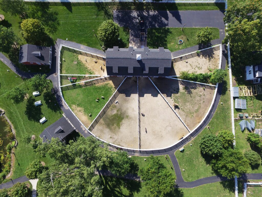 Drone/aerial view over enclosures for Heritage Park Petting Farm's animals