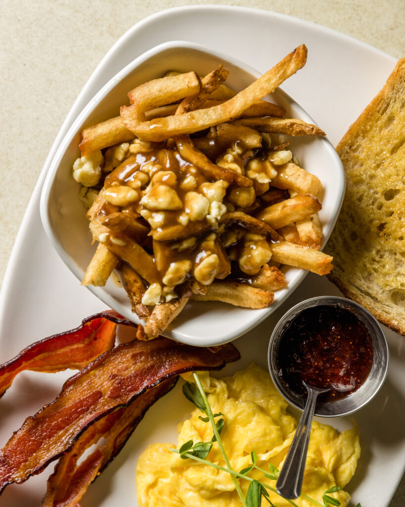 brunch from brooklyn street local. plate of bacon, eggs, jam and toast, and poutine fries
