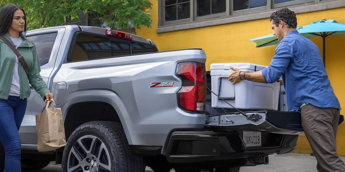Chevy Colorado truck with cooler being loaded in the bed