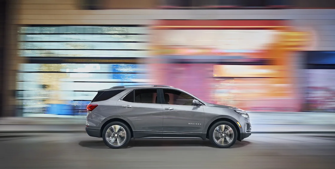 Chevy Equinox zooming past buildings, creating a focus on the vehicle