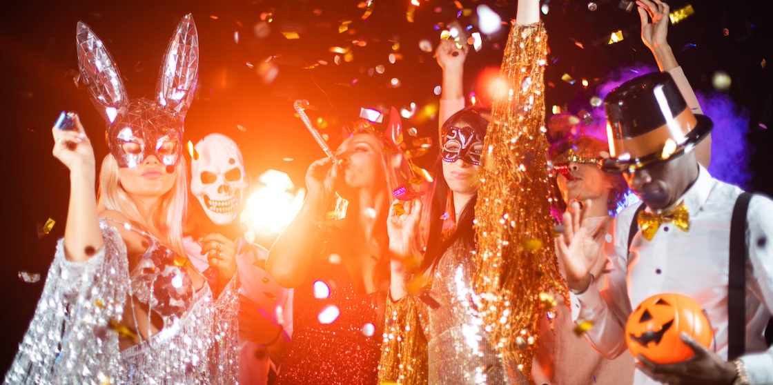 costumed people dancing with masks and orange lights