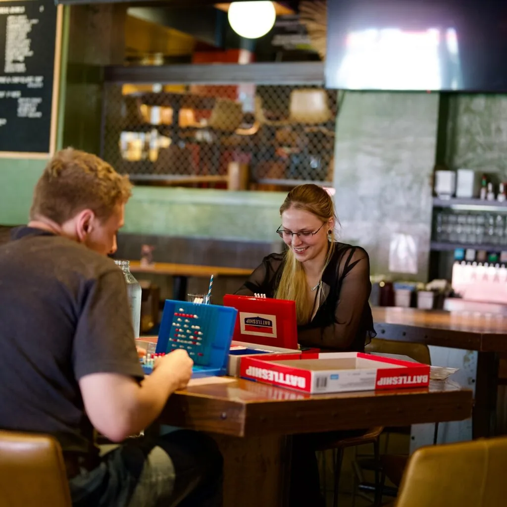 couple playing battleship at the corner