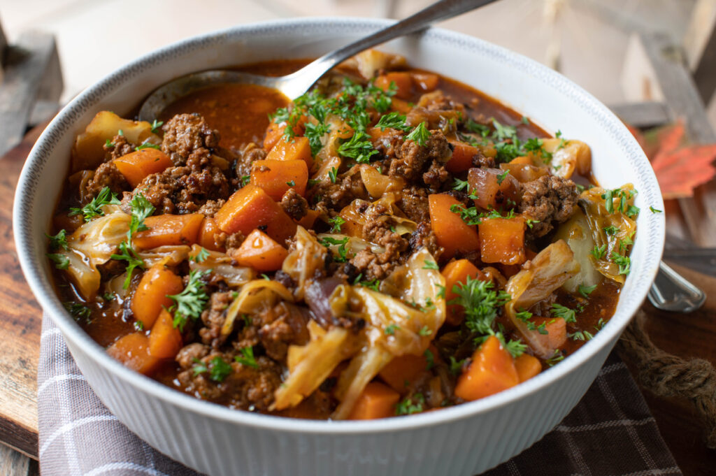 hearty stew with autumn produce using carrots, cabbage, beef, and more