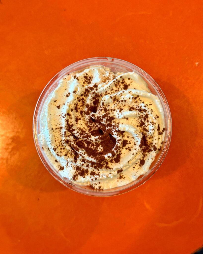 the office coffee shop fall seasonal beverage with whipped cream and cinnamon on top