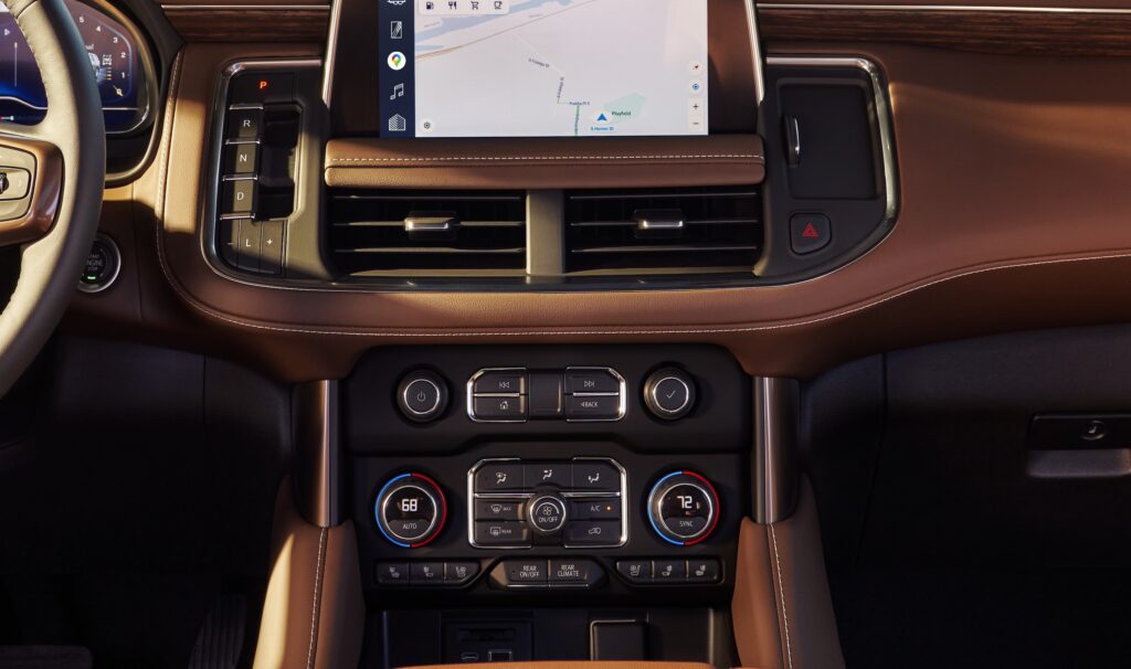 Suburban tan interior with center console charging under infotainment system screen