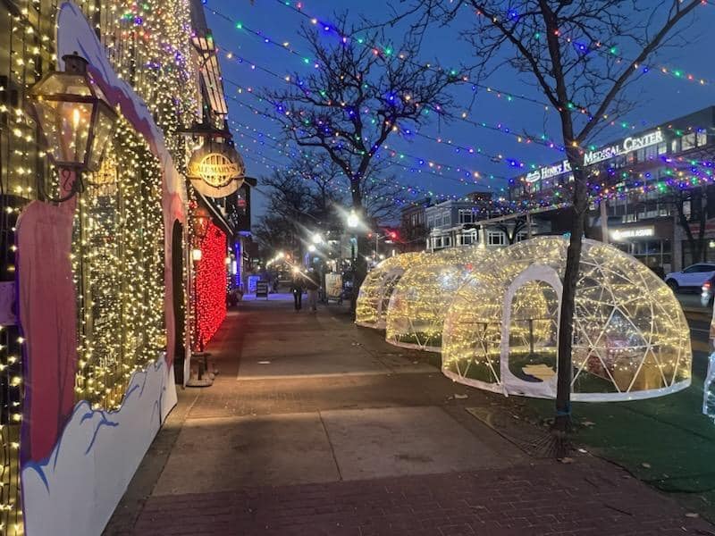 heated igloos with christmas lights outside of the jingle at ale mary's