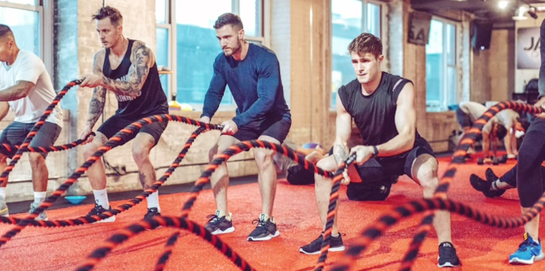 several men working on fitness goals with ropes
