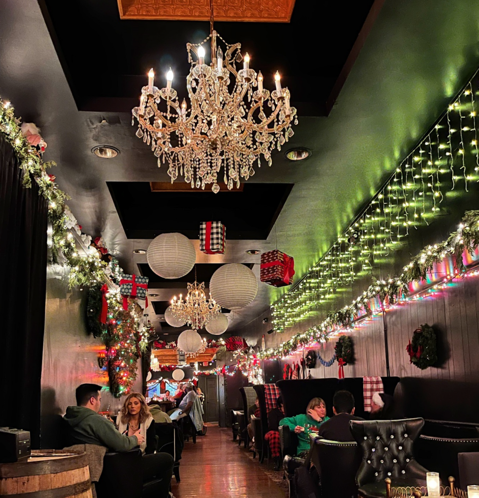 The Oakland Miracle pop up bar decorated with lights and hanging gifts