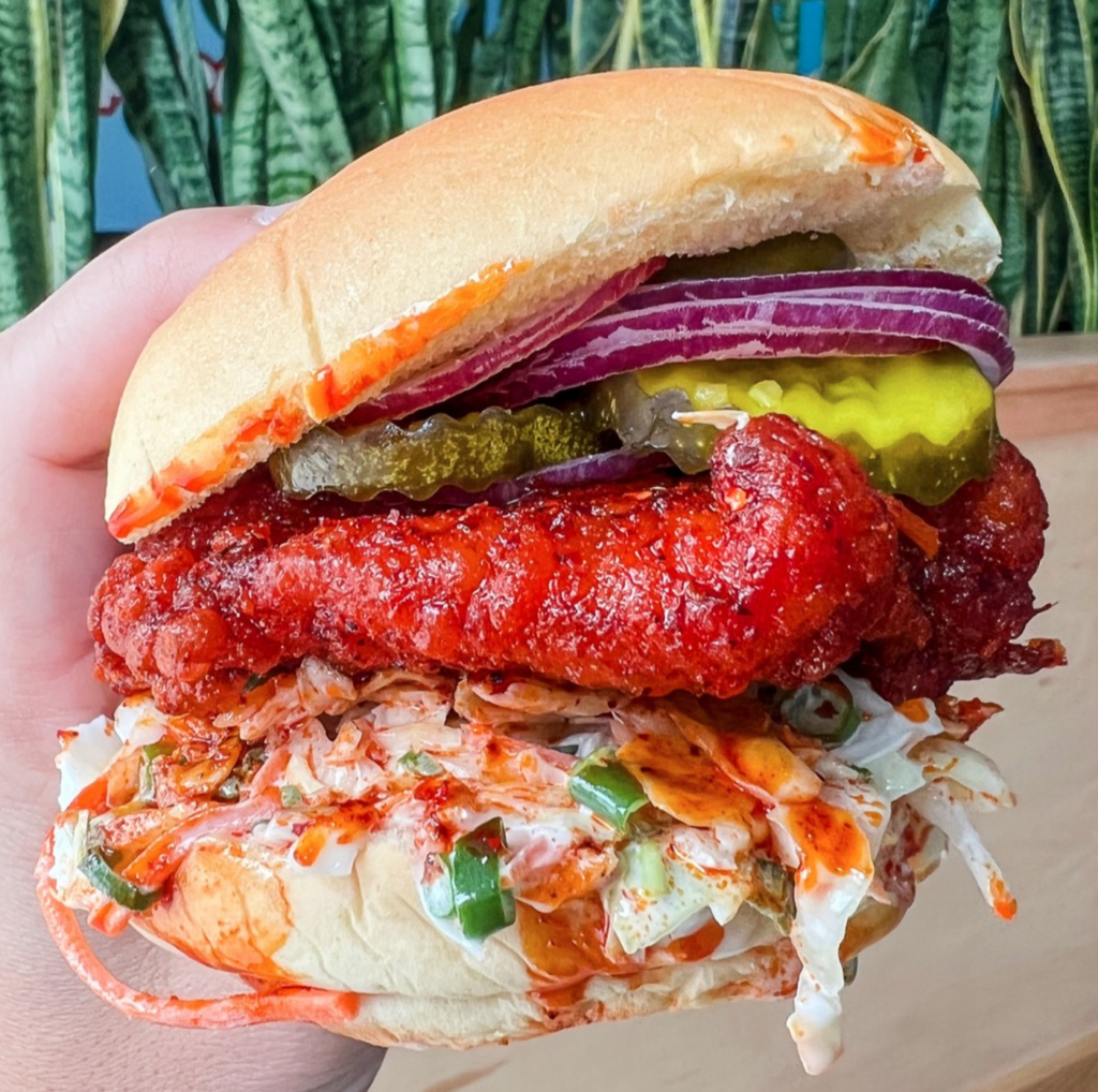 spicy chicken sandwich from supercrisp with red onion, pickles, hot chicken, and cole slaw