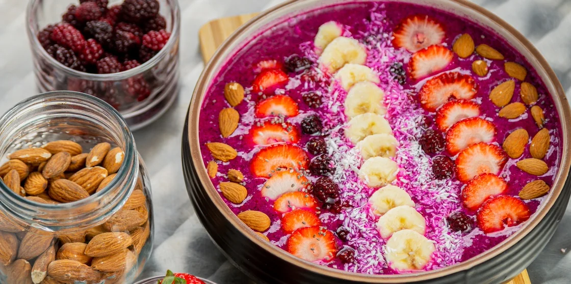 Açai bowl with banana, berries, almonds, strawberries, coconut.