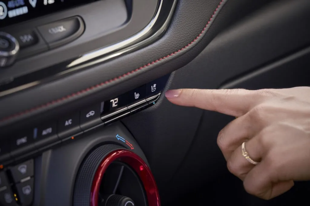 women's finger adjusting climate control for the seat