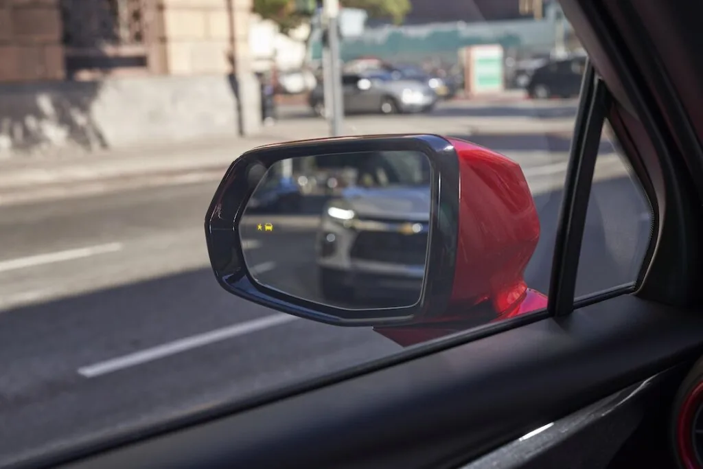 red blazer driver side mirror with another chevy in the view