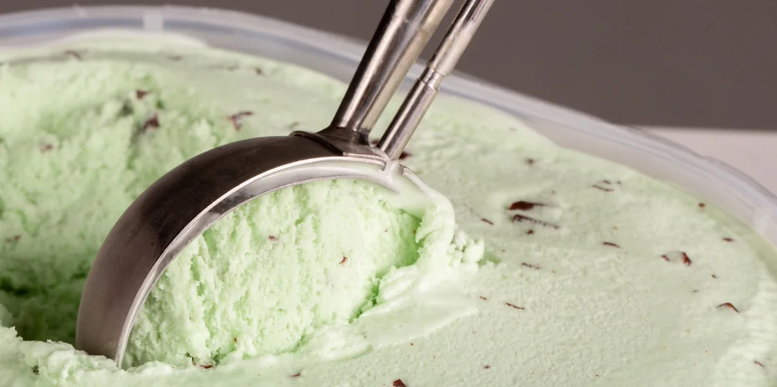 Mint choc chip ice cream being balled up by a mechanical scoop