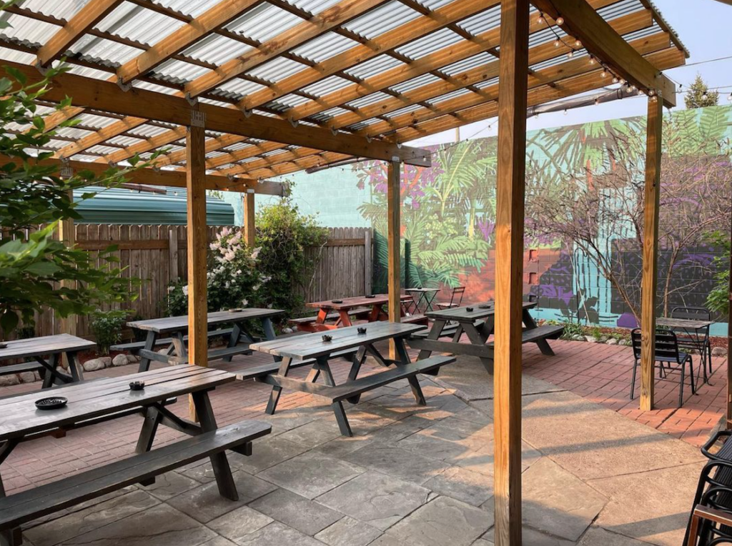 covered patio space at bumbos bar with greenhouse mural by michael burdick