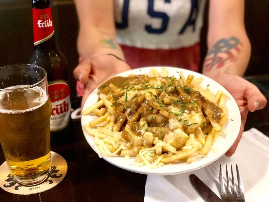 plate of poutine served with a beer