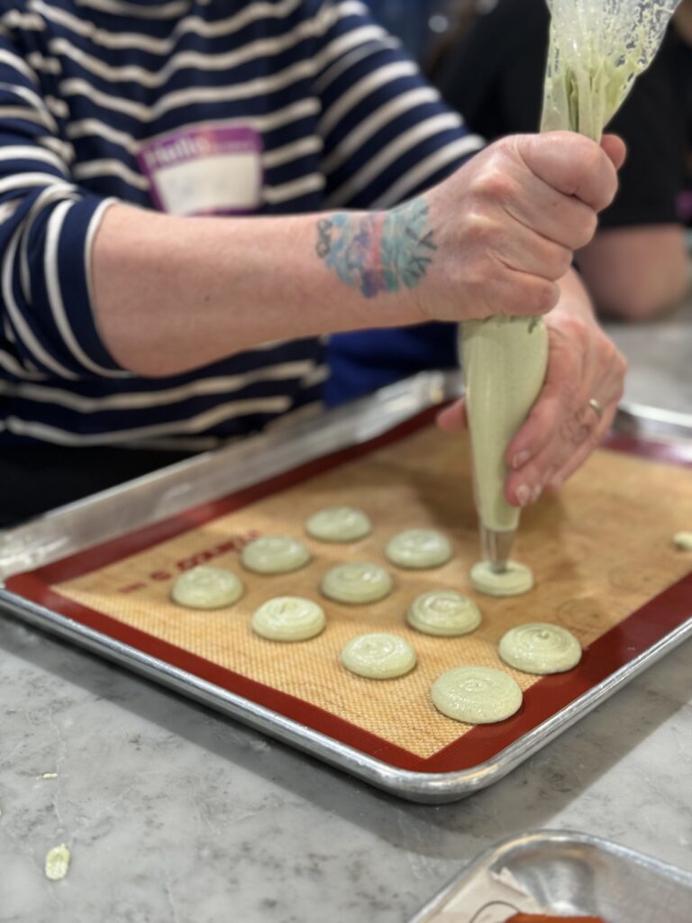 macaron piping on a lined bakery tray