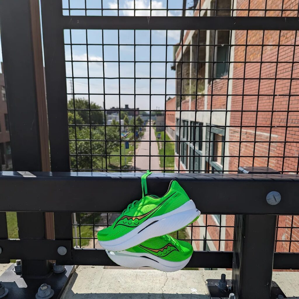 green running shoes tied to a fence