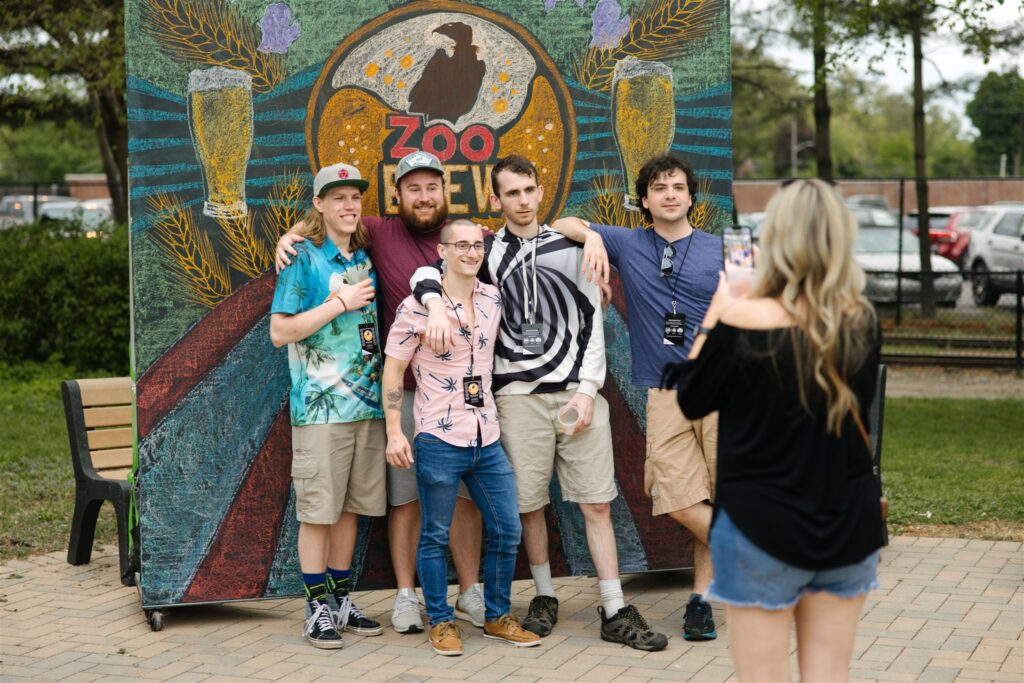 zoo brew at detroit zoo picture backdrop with a woman taking a group of men's pictures for may events