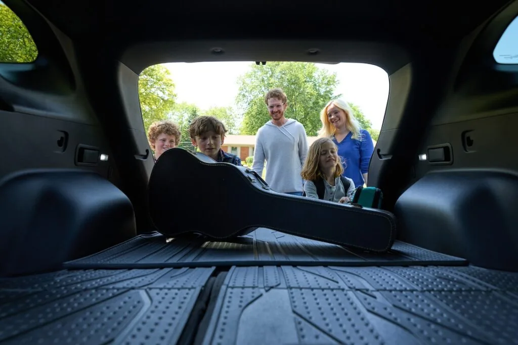 family loading the cargo space of the blazer with a guitae case