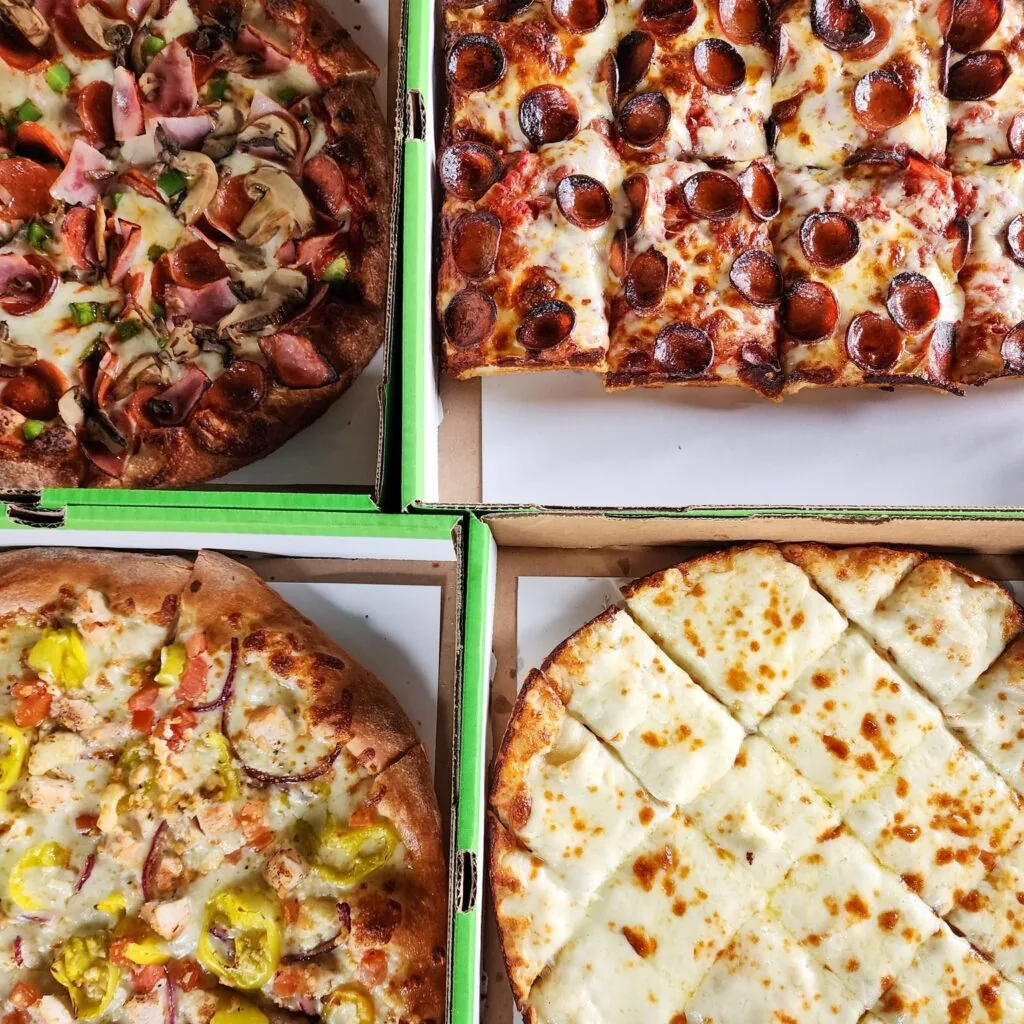 boxes of pizza and cheese bread from green lantern pizza