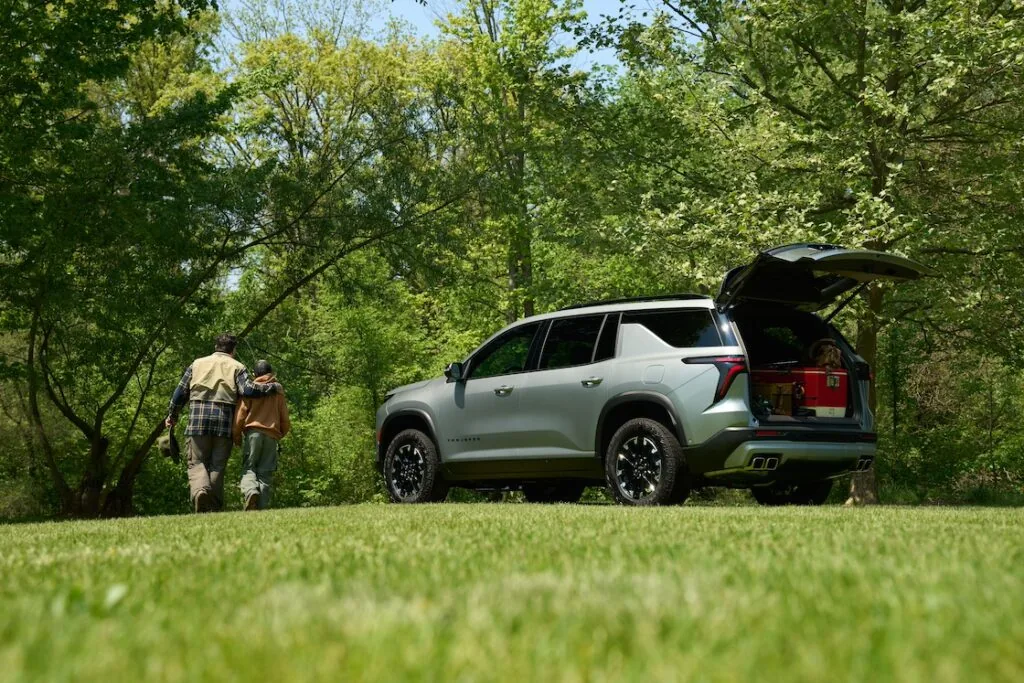 loaded cargo space in an all-new silver traverse as father and son walk away from the vehicle