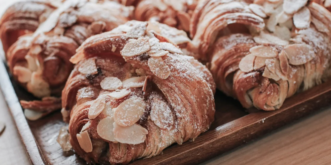 Traditional French breakfast pastry tray with gold and crispy almond croissants.