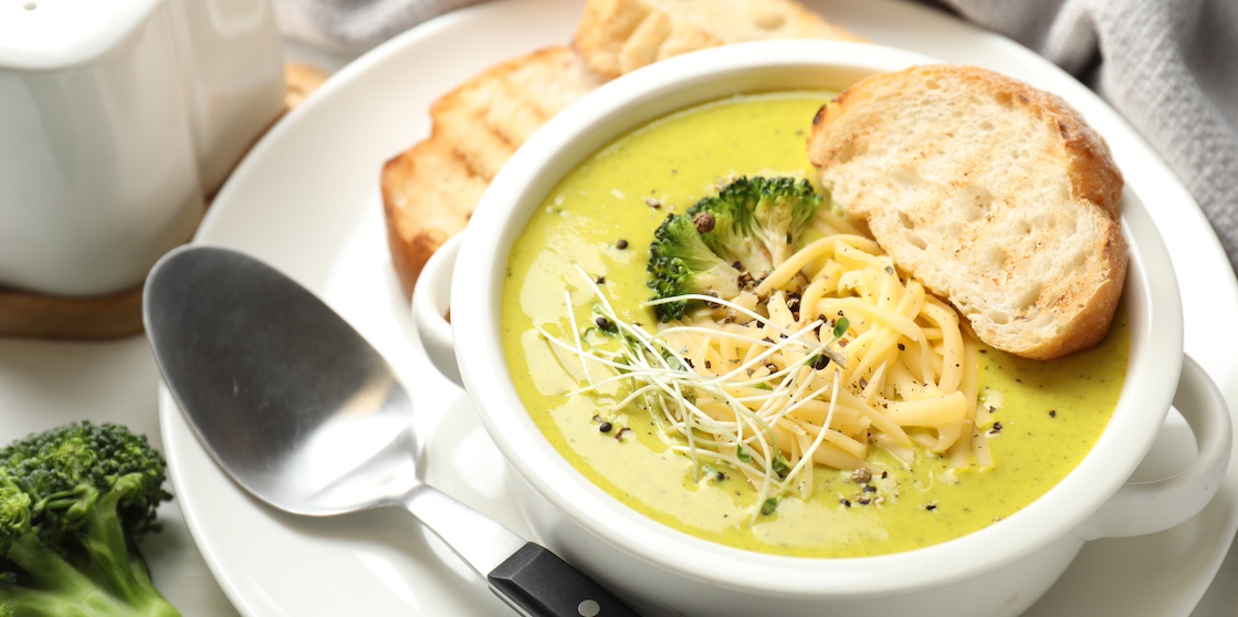 broccoli cream soup served on table with bread