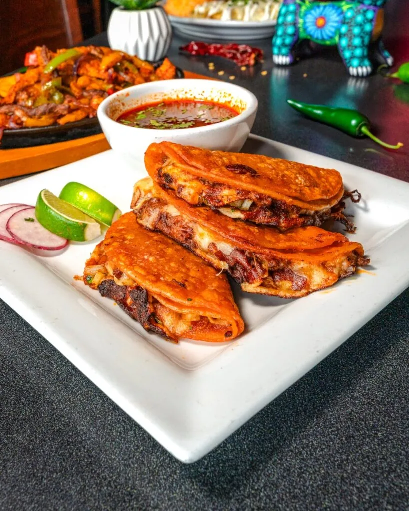 Quesabirria tacos with a cup of consome from Mezcal