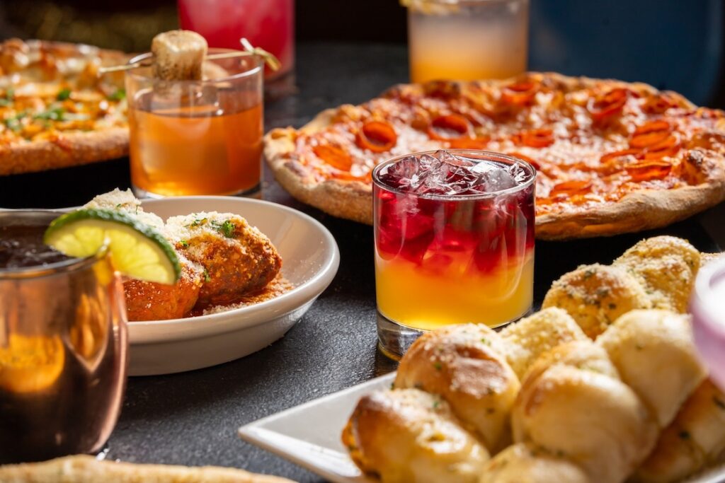 Mootz Pizzeria + Bar spread of cocktails, garlic knots, meatballs, and pizzas