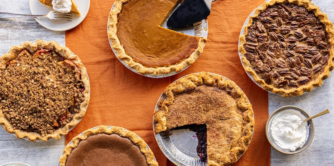Pie assortment on table with bowls of cool whip