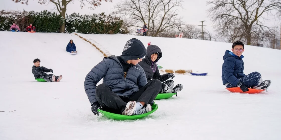 Boys sledding in Valade Park - Winter Round Up