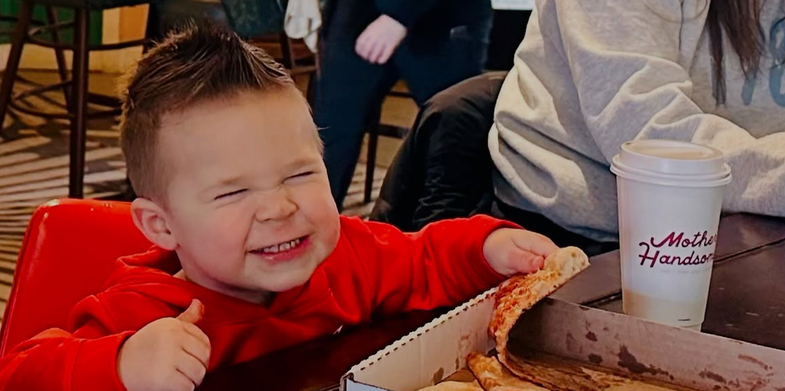 weekend fun - kid smiling and eating pizza at Mother Handsome in Oak Park