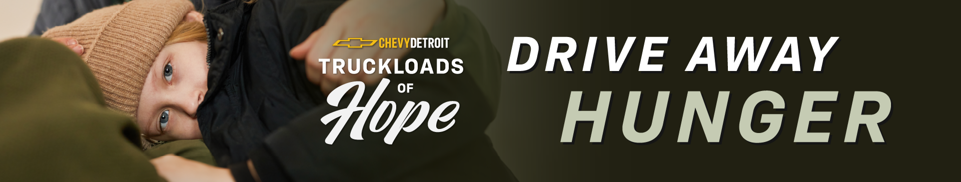 Child wearing a winter hat and coat resting against an adult, with text reading 'Chevy Detroit Truckloads of Hope – Drive Away Hunger.'