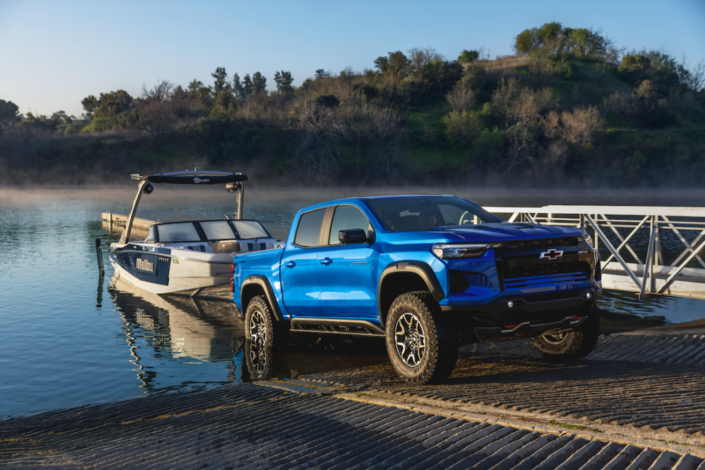 Blue Silverado ZR2 with a boat in the water