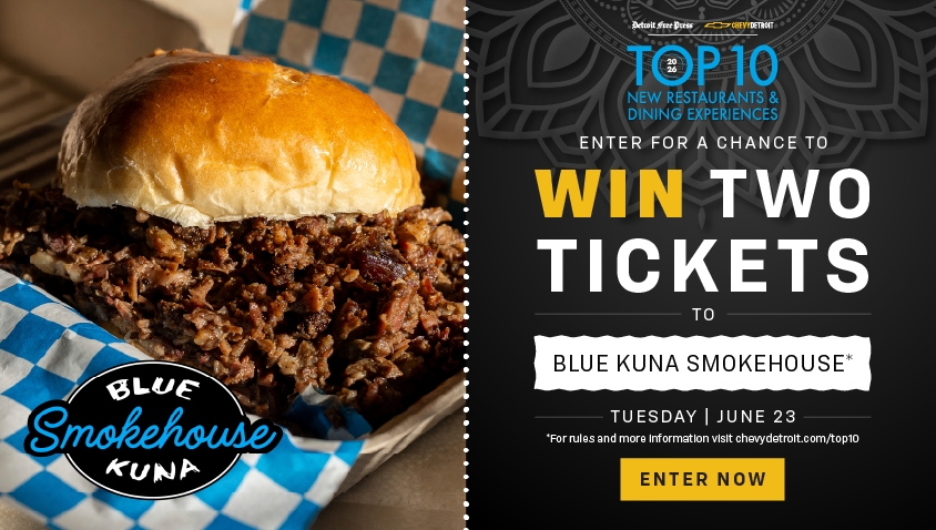 A mouthwatering pulled pork sandwich on a brioche bun, served in a blue-and-white checkered basket, alongside a promotional graphic for the Detroit Free Press and Chevy Detroit Top 10 New Restaurants & Dining Experiences sweepstakes. Text reads: "Enter for a chance to WIN TWO TICKETS to Blue Kuna Smokehouse – Tuesday, June 23. Enter Now."