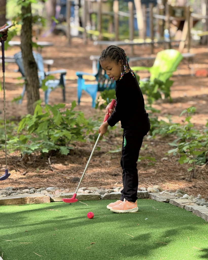 Young mini golf player at TreeRunner Adventure Parks