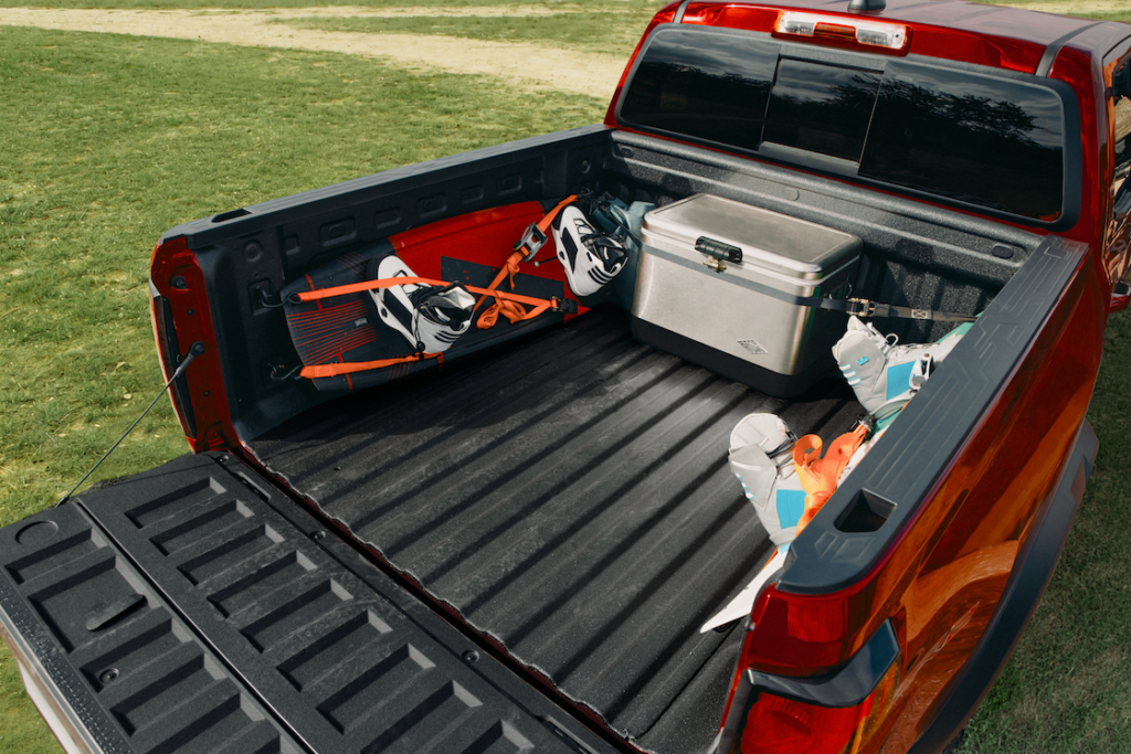Colorado truck bed with a cooler and wakeboards tied down.