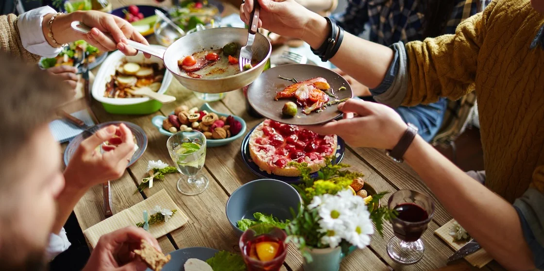 family-style meal - People sitting at dining table and sharing plates